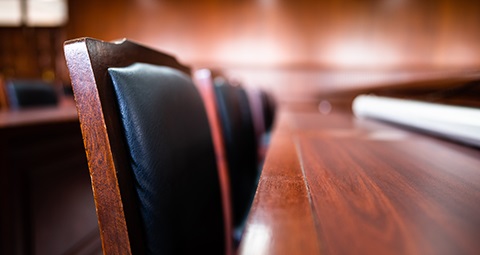 A chair pushed up against a desk in a courtroom.